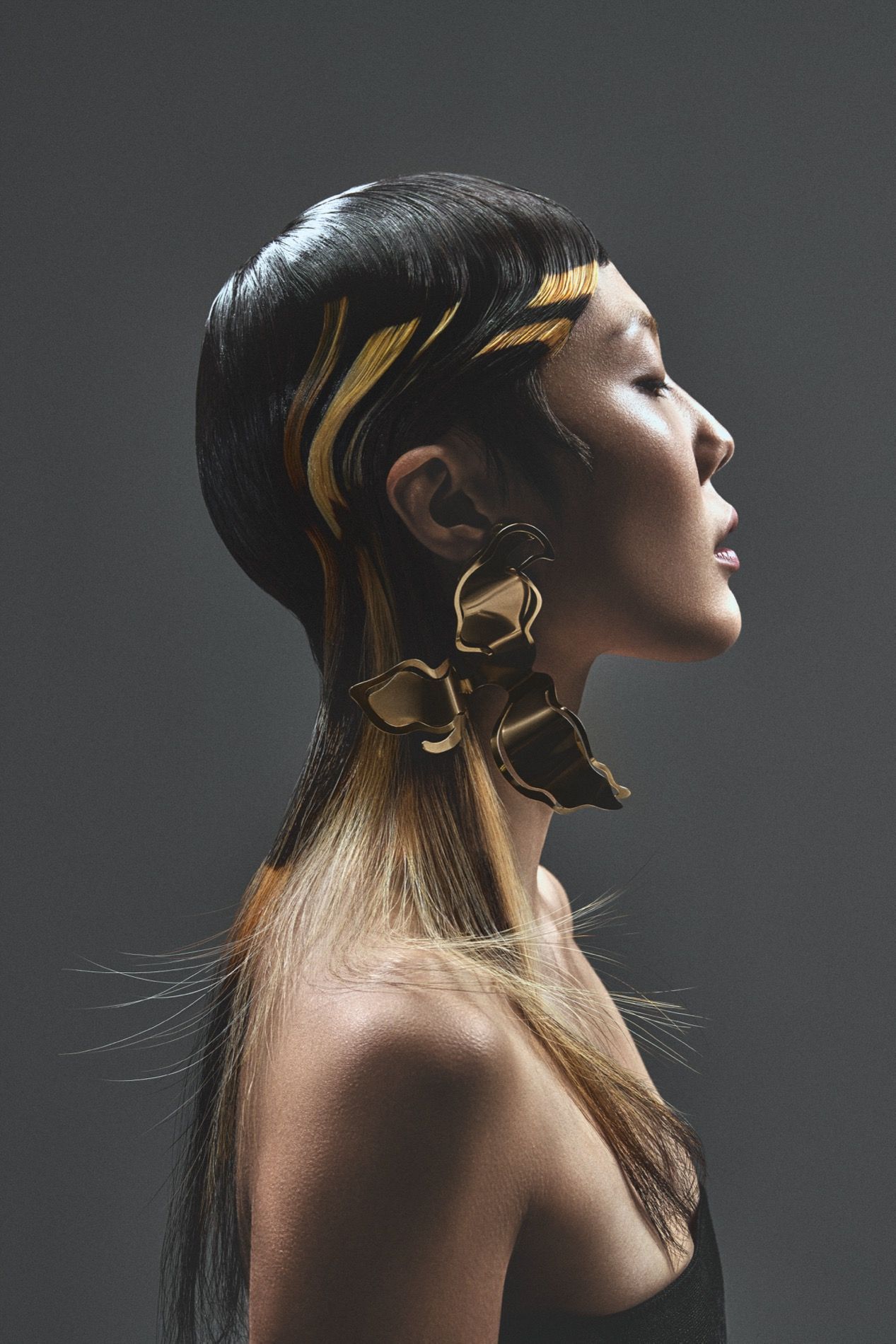 Hair editorial, sleek haar met goud in profiel en gouden oorsieraad